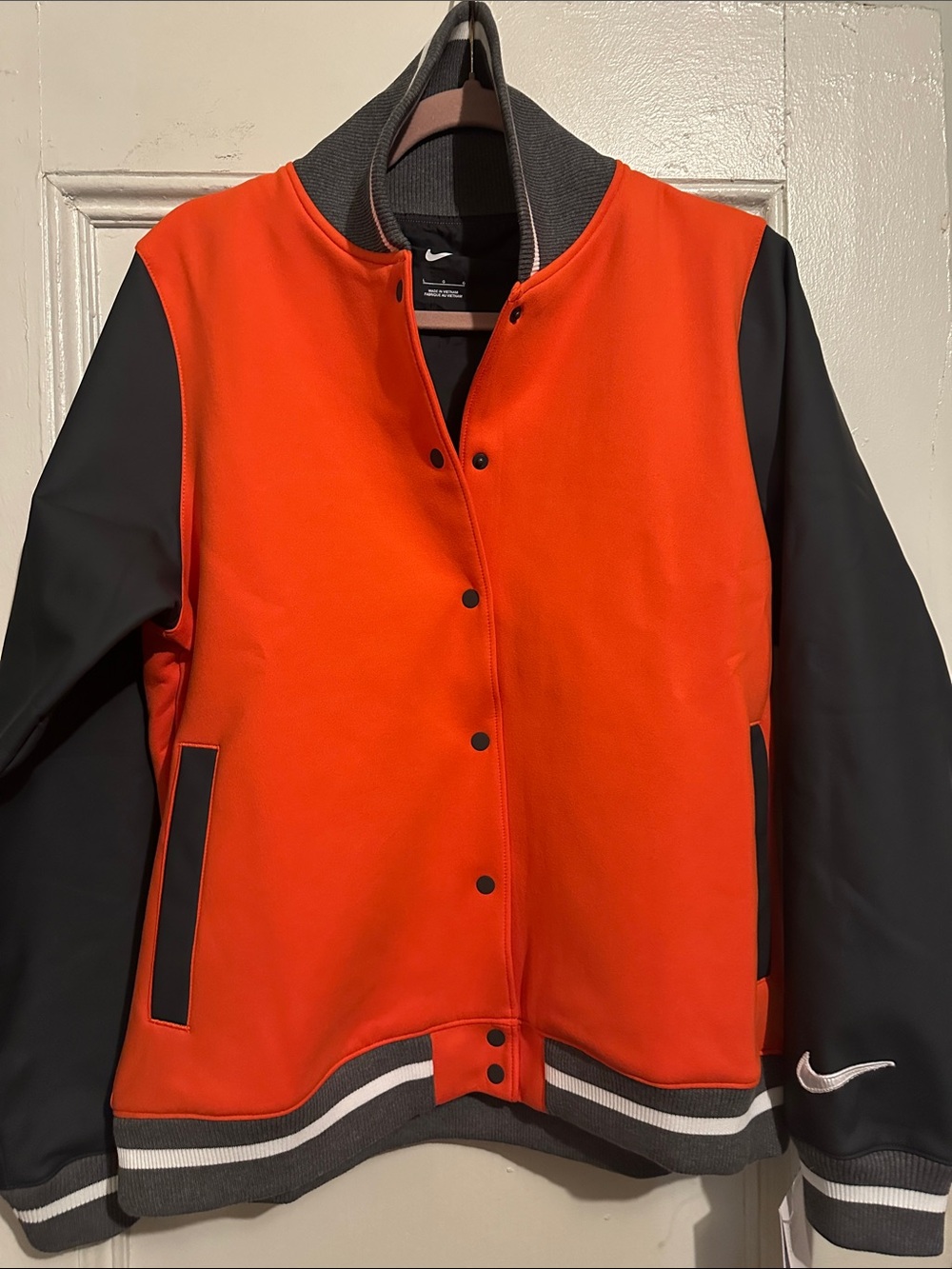 NWT Nike Women’s Orange and Black Varsity-Style Jacket. 30”L x 20.5”W. Size L.